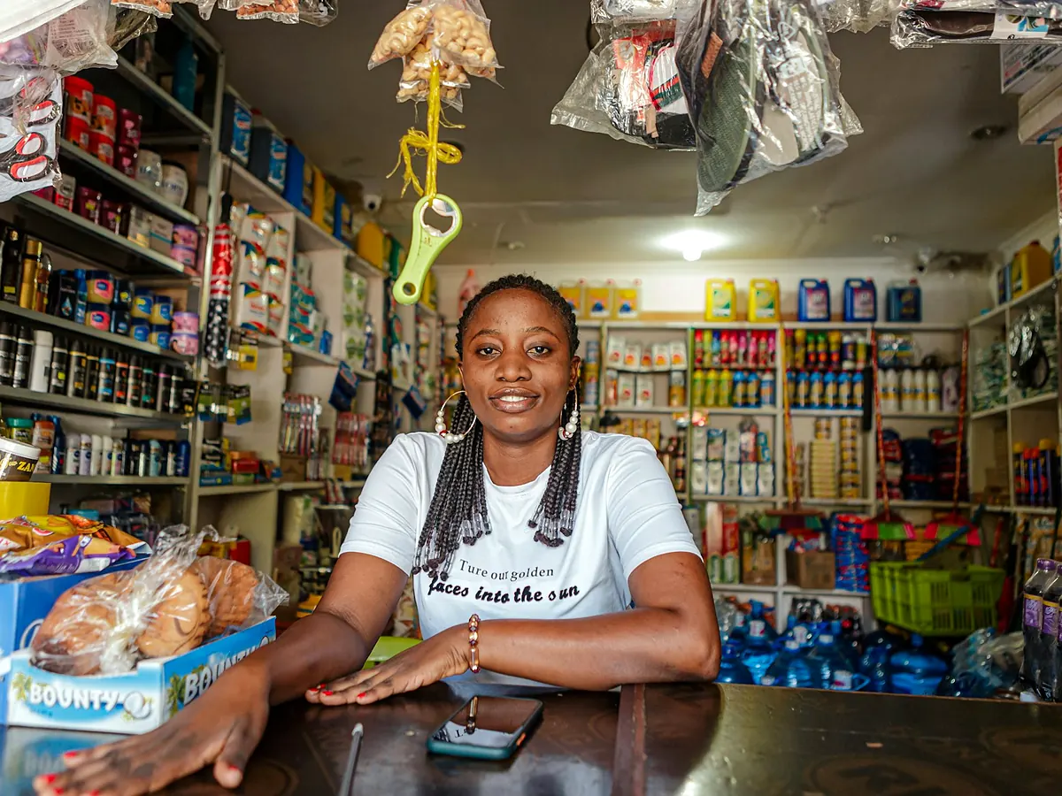Empreendedora sorrindo no balcão da sua loja