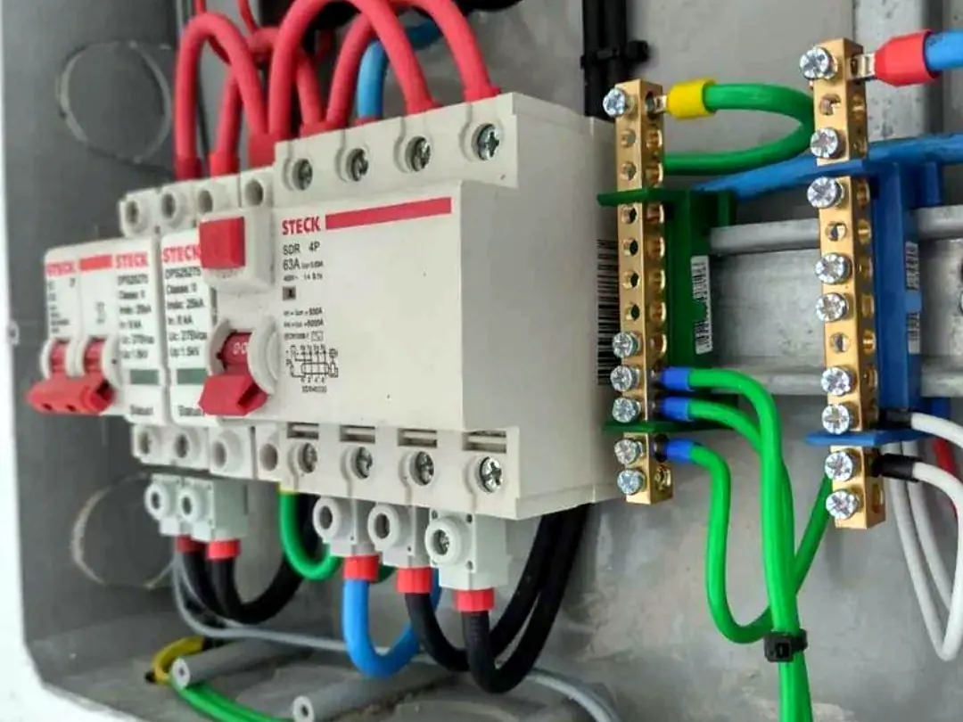 Barramento de terra e DPS instalados no quadro, com condutores verdes de aterramento