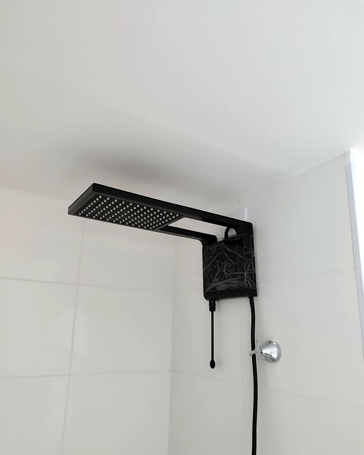 Chuveiro elétrico instalado em banheiro com azulejo