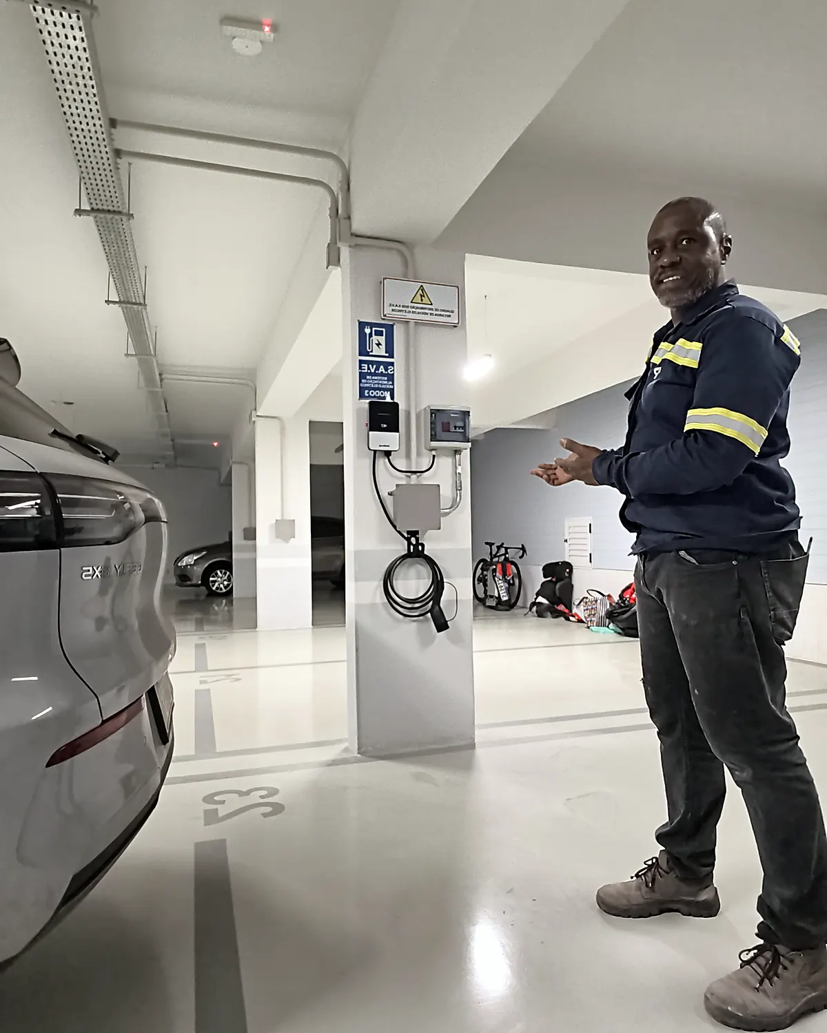 Eletricista Ronaldo Américo na garagem de condomínio com infraestrutura elétrica para recarga de veículos