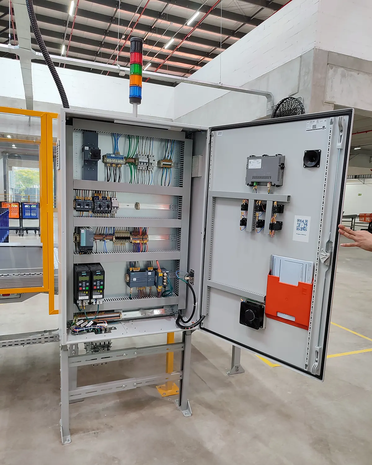 Painel elétrico de galpão com a porta aberta e os componentes de comando