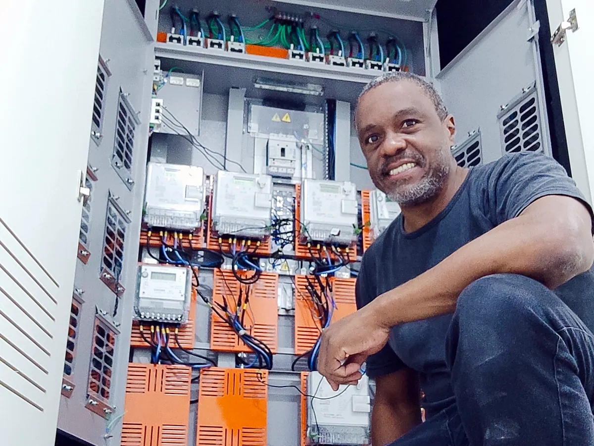 Ronaldo Américo junto a quadro com medidores de energia e barramentos