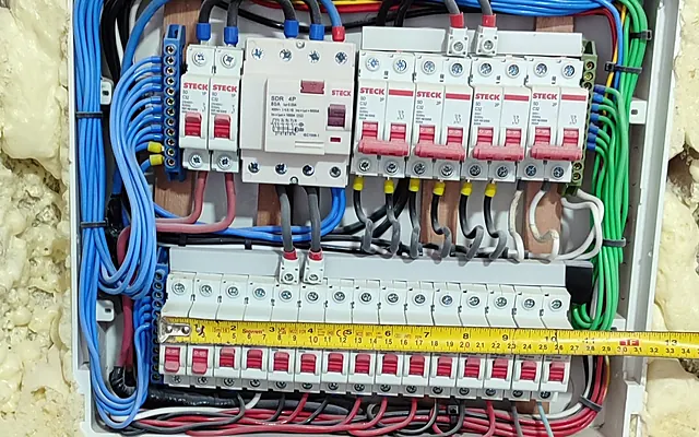 Quanto custa um eletricista na Zona Norte de SP? Preços 2026 — Quadro de distribuição com disjuntores, DR e fiação organizada por cores