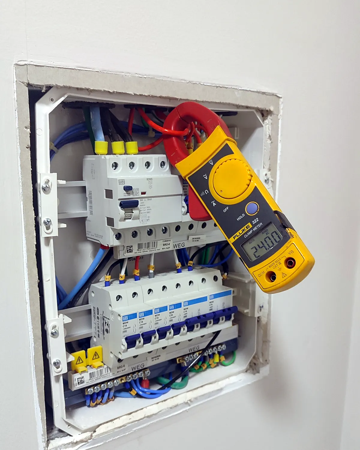 Quadro residencial em medição com alicate amperímetro