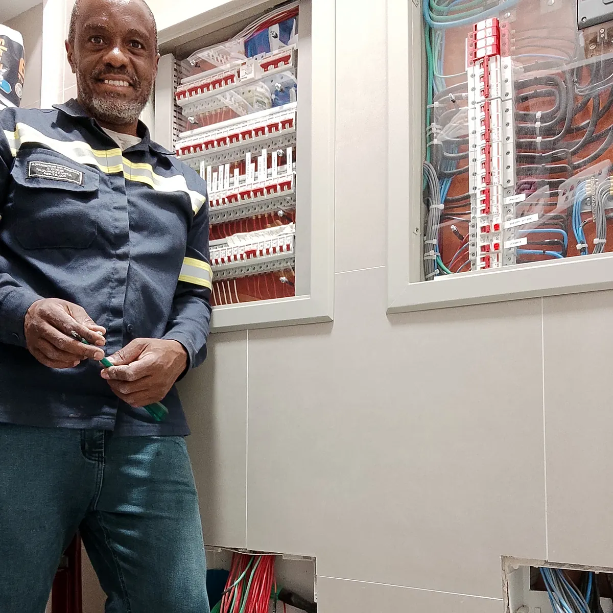 Ronaldo Américo com quadros de distribuição instalados na parede