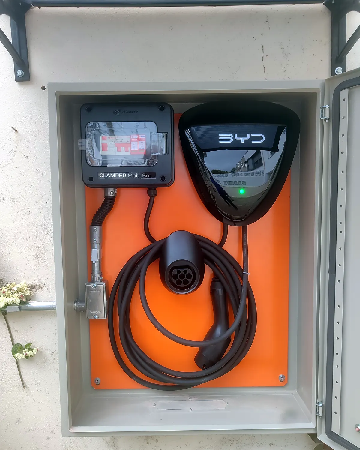 Carregador BYD instalado dentro de abrigo metálico, com caixa de proteção